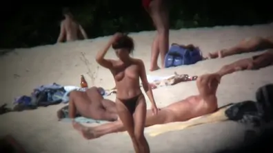 Hot ladies with appetizing breasts rest on the wild beach
